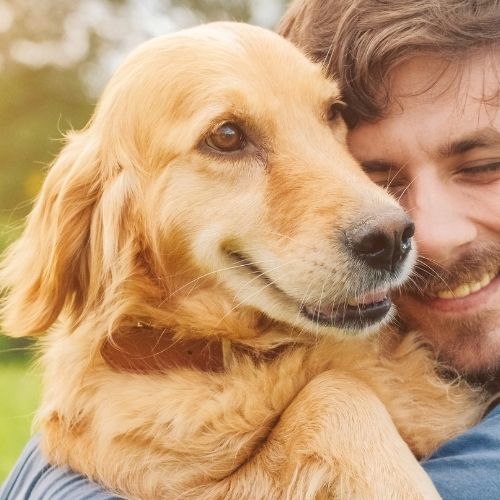a men holding a pet dog